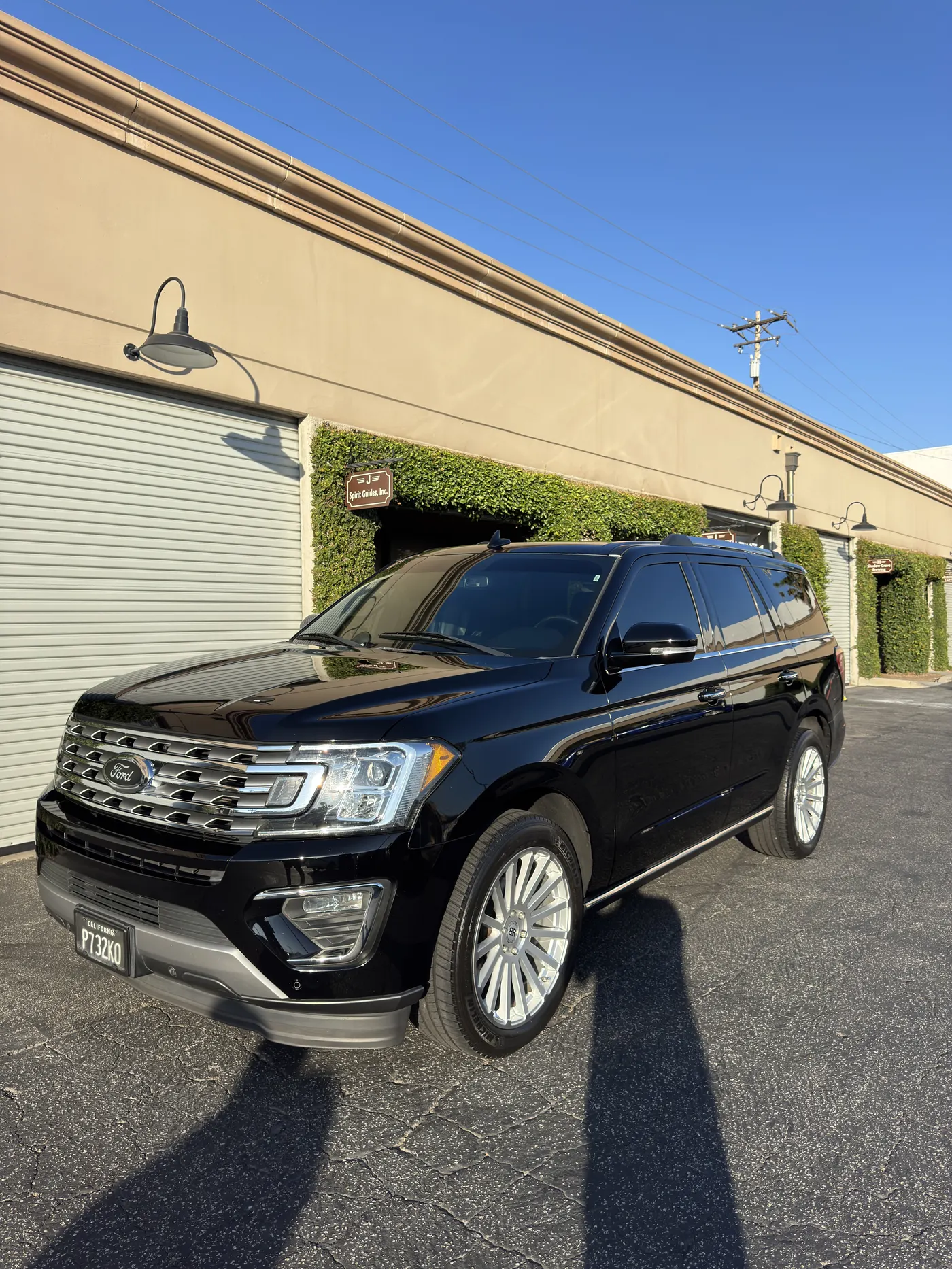 Black luxury SUV with dark ceramic tint in the shop bay